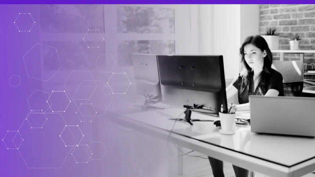 Woman working at a desk with multiple computer monitors, symbolizing productivity and focus in a modern office environment, with abstract hexagon graphics on a purple gradient background indicating technology and innovation.