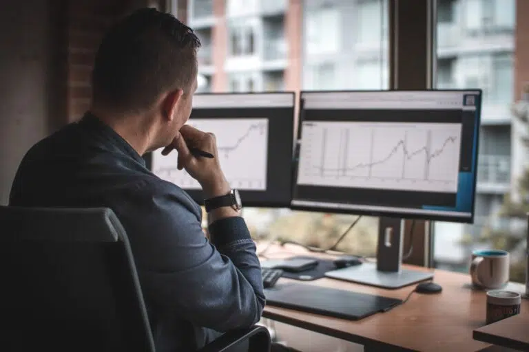 A man hired as an MSP for cloud solutions, reviewing performance statistics on a computer.