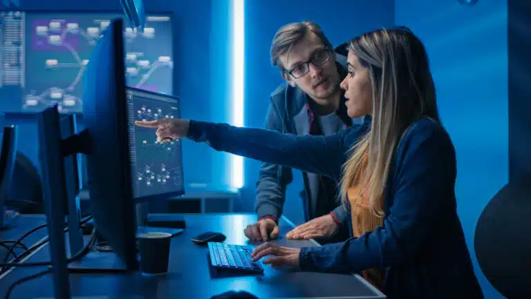 Two IT professionals monitoring a client's IT security services