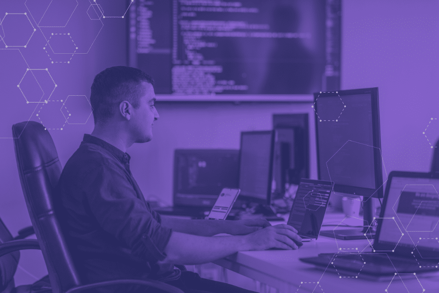 IT administrator using a centralized management system to monitor and control devices, security policies, and software updates from a single dashboard.