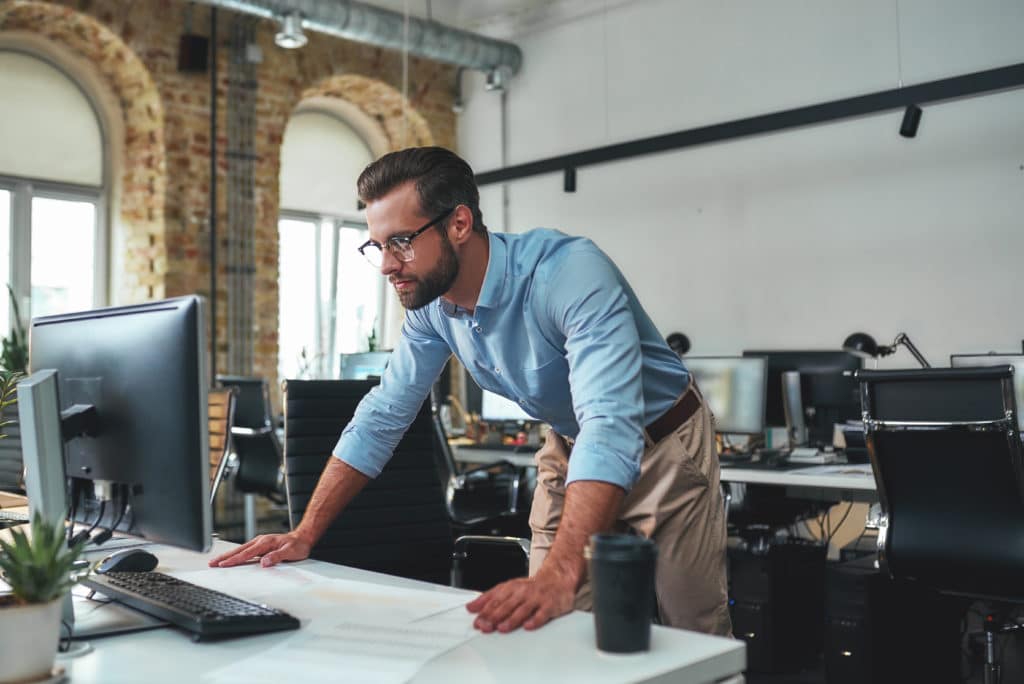 A fractional IT director leaning over a computer