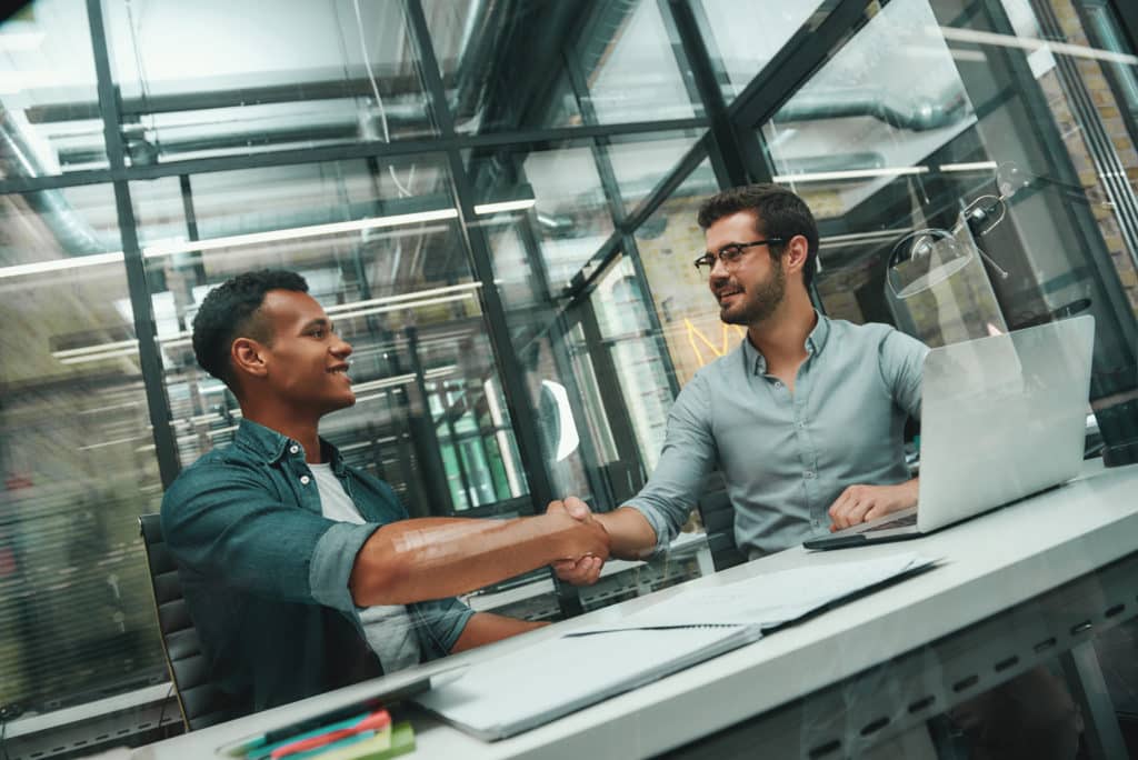 An HR professional greeting a new employee during onboarding