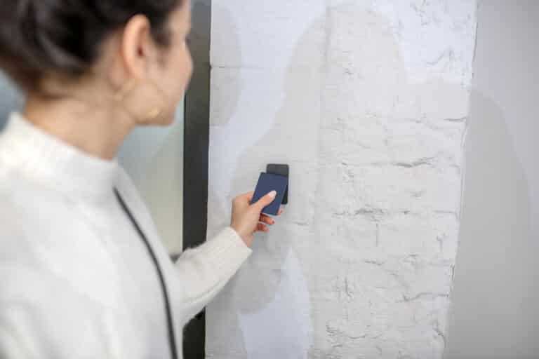 A woman using a keycard to enter a room, an example of identity and access management.