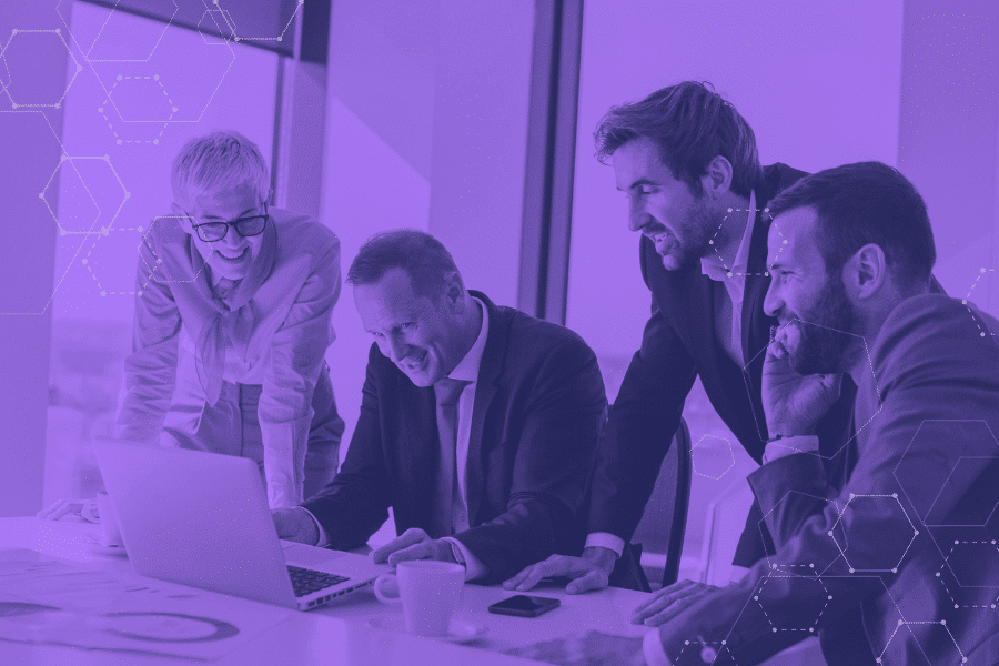 Professionals working together with laptops, symbolizing businesses preparing for Windows 10 end of life by planning upgrades, managing cybersecurity risks, and ensuring regulatory compliance.